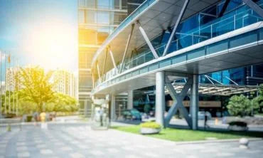 Modern building with glass facade and sunlit sky